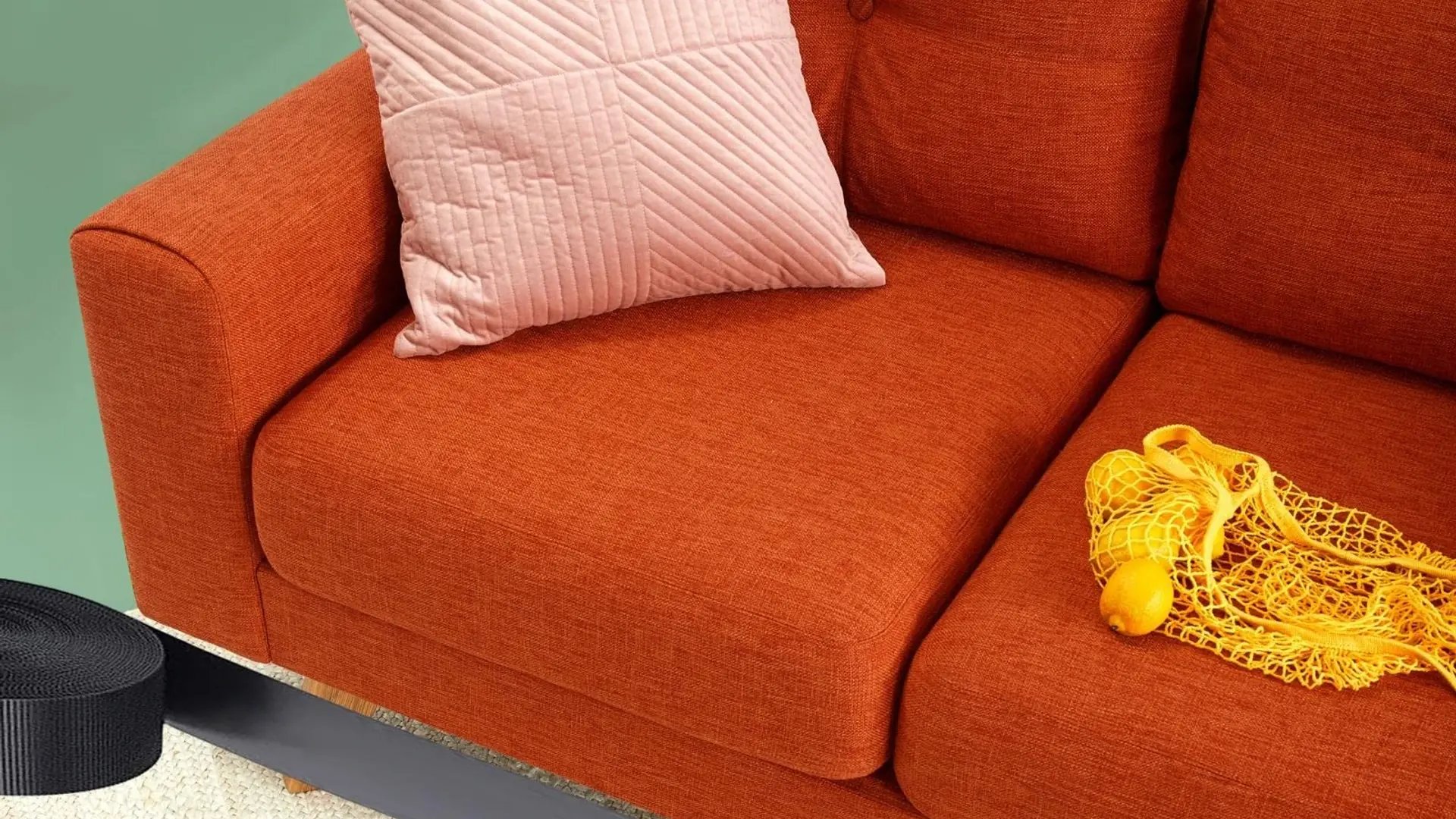 Modern orange sofa with decorative pillows in contemporary living room - Sharma Space interior design showcase